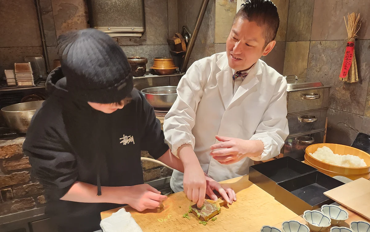 A young boy learning how to prepare fresh wasabi